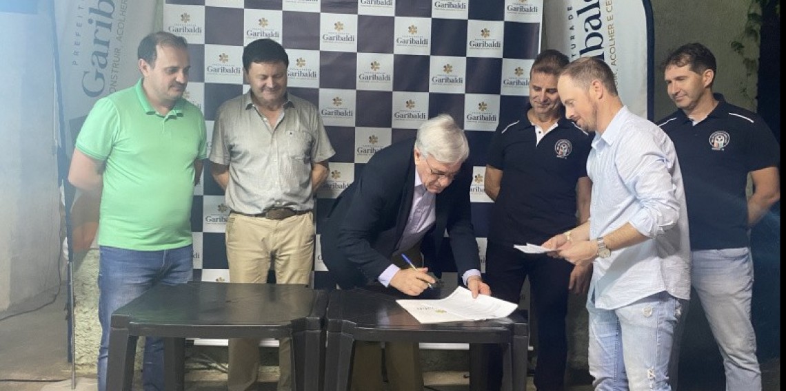 Assinatura do Prefeito Sérgio Chesini sob os olhares do Vice Prefeito Vlalério Mayer e do Presidente da Câmara. Cassio Fachi
